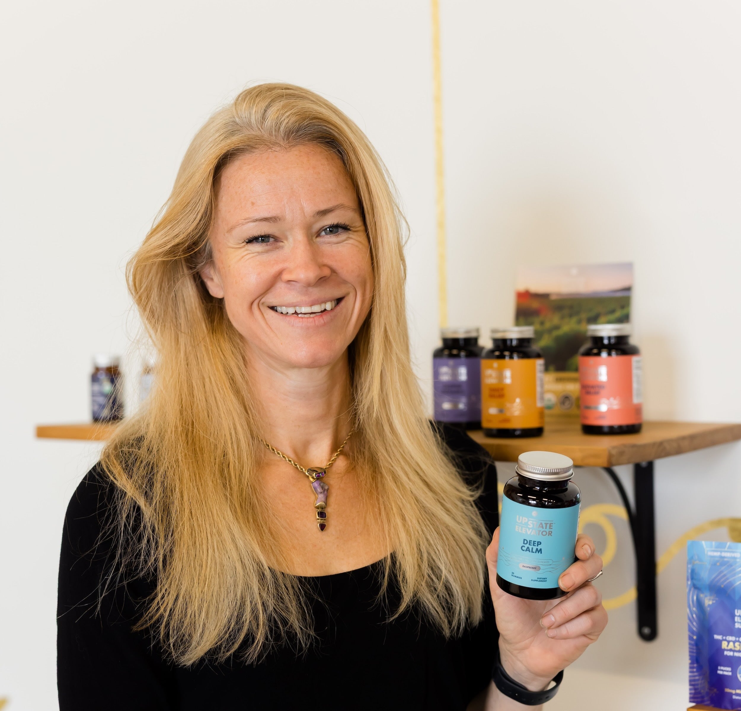 Woman holding a supplement bottle in a store setting with various products on shelves.