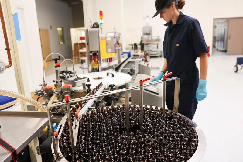Technician overseeing CBD oil bottle production line at Upstate Elevator’s Vermont facility